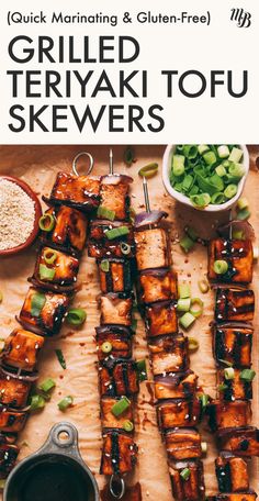 grilled teriyaki tofu skewers on a cutting board with sauce