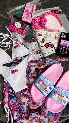 hello kitty swimsuits and accessories are laid out on a bed with a cell phone