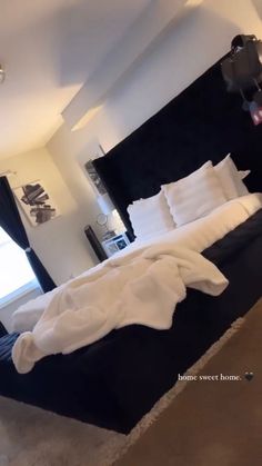 a large bed sitting in a bedroom next to a window