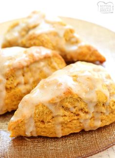 three biscuits covered in white icing on a plate