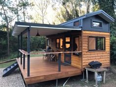 a small wooden house with a porch and covered patio