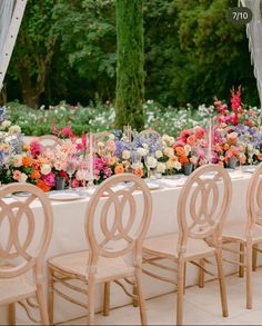 an outdoor table set up with flowers and candles on it for a formal dinner or party