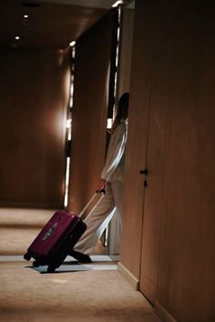 a person with a suitcase walking down the hallway