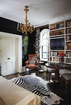 a living room filled with furniture and a zebra rug