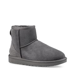 These women's UGG Classic Mini II grey boot is designed to keep you warm and on-trend, without the heavy weight. Made with soft sheepskin upper, these cold weather booties have a round toe front, easy slip-on design, Post-Applied Treatment Treated to repel light amounts of water, rear pull tabe, soft sheepskin lining, polyester binding, suede heel counter with embossed UGG logo heel label, and a durable Treadlite by UGG lightweight outsole. | Ugg Women's Classic Mini II Boot in Grey Suede Size 9 Ugg Mini Bailey Bow, Ugg Classic Mini Ii, Ugg Boots Outfit, Classic Ugg Boots, Ugg Classic Mini, Shearling Boots, Sheepskin Boots, Grey Boots, Ugg Classic