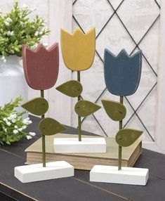 three wooden flowers are sitting on a table