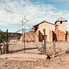 an old building in the middle of nowhere with a clock on it's side