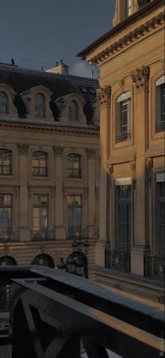 an old building with many windows and balconies in the evening sun, as seen from a balcony