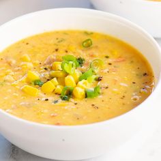 two white bowls filled with soup on top of a table