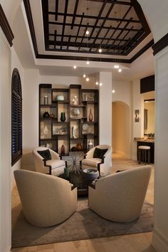 a living room filled with lots of furniture and bookshelves on the wall next to each other