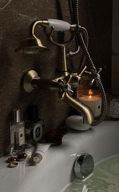 a bathroom sink with a candle, soap dispenser and other items on it