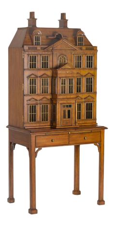 a wooden doll house on top of a table with drawers and an open drawer underneath it