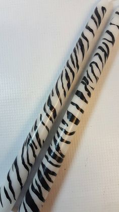 two zebra print pens sitting next to each other on a white tablecloth covered surface