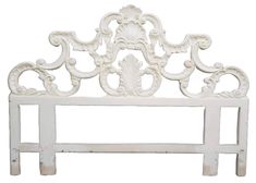 a white headboard with an ornate design on the top and bottom, against a white background