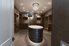 an empty walk - in closet with lights on the ceiling and wooden cabinets around it