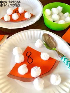 three paper plates with different types of food on them, one is orange and the other has white pom - poms