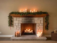 a fireplace decorated with candles and greenery