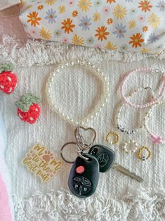 several items are laid out on a blanket with beads, keys, and other accessories