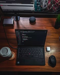 an open laptop computer sitting on top of a wooden desk next to a mouse and keyboard