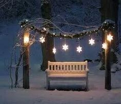 a park bench covered in snow with lights on it