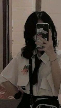 a woman taking a selfie in front of a mirror wearing a tie and white shirt