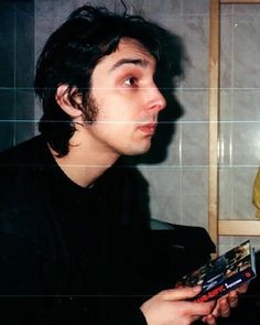 a young man holding a box of pizza in his hand