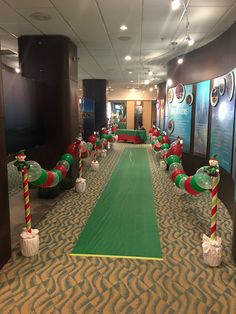 an indoor golf course decorated for christmas with candy canes on the green and red poles