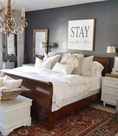 a bed room with a neatly made bed and a chandelier hanging from the ceiling