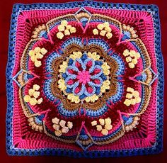 a crocheted square with flowers and leaves on the center in pink, blue, yellow and brown