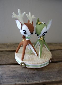 two small stuffed animals sitting on top of a wooden table