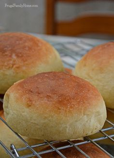 three round bread rolls cooling on a wire rack