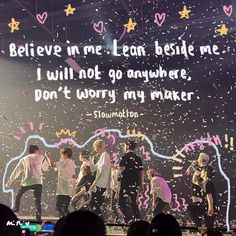 btt performing on stage with confetti in the air and words above it