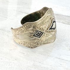 Vintage Silver Plated Southwestern Cuff Bracelet Beautifully Engraved Beautifully and meticulously engraved with enamel accents in navy blue at the center. The design is a mixture of geometric and flowing leaves or feathers pattern. The engraving is somewhat deep and likely not cast. Estimated to date from the 1970s. The cuff is 1 5/8 inches at the widest point. It measures 6 3/8 inches long plus the 7/8 inch opening. It can be adjusted but the metal gauge is heavy. Weighs 1.8 ounces. In good co Metal Gauge, Feathers Pattern, Gold Waves, Jewelry Tags, Feather Pattern, Vintage Costume Jewelry, Vintage Costumes, Set Vintage, Link Bracelets