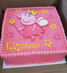 a pink birthday cake with peppa the pig on it's side in a box