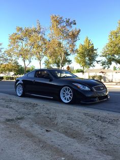 a black car is parked on the side of the road