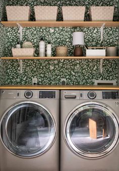 a washer and dryer sitting next to each other in front of a green wall