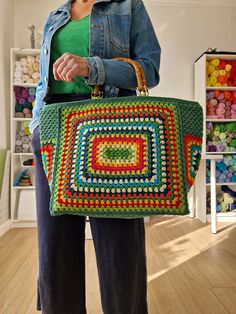 a woman holding a crocheted bag in her hands