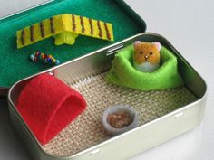 two tins filled with small toys on top of a table