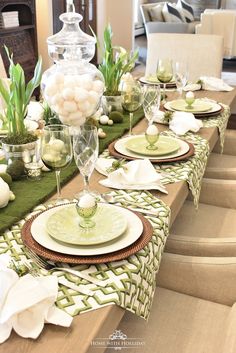 the table is set with white flowers and green place settings for dinner or brunch