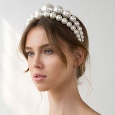 a woman wearing a headband with pearls on it