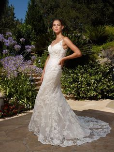 a woman in a wedding dress posing for the camera with her hand on her hip