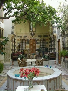 an outdoor living area with flowers and chairs