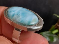 "This unique gem is found in the Dominican Republic. This is almost the only place where the Larimar was found in the world. Delicate Caribbean water tones that are reminiscent of the beautiful island, the sea of the Caribbean. Due to the white structure, it is like seeing the sea floor in the ocean. P.S. When ordering, always state the ring size so that we can set the appropriate size. The larimar is a special variety of the mineral pectolite and is also known as the Atlantis stone. The stone bears its interesting name Larimar due to its two discoverers, Norman Rilling of the US Peace Corps and the Dominican Miguel Méndez, who combined the name of his daughter Larissa and the Spanish name for sea \"Mar\" because of the unique color of the stone. We obtain our Larimar direct from the sourc Unique Silver Larimar Rings, Silver Larimar Ring Stamped 925, Silver Larimar Oval Ring, Spanish Names, Sea Floor, Peace Corps, Larimar Ring, Larimar Rings, Les Chakras