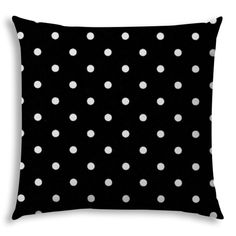 a black pillow with white polka dots on the front and back, it has a dark background