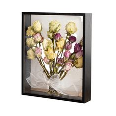 a bouquet of flowers in a glass box with a white bow on the front and side