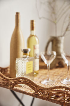 wine glasses and bottles on a wicker table