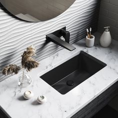 a bathroom sink sitting under a mirror next to a faucet and vase with flowers