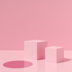 three white cubes sitting on top of a pink floor next to a round object