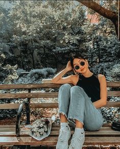 a woman sitting on top of a wooden bench