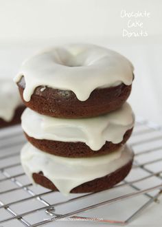 chocolate cake donuts with white icing on a cooling rack